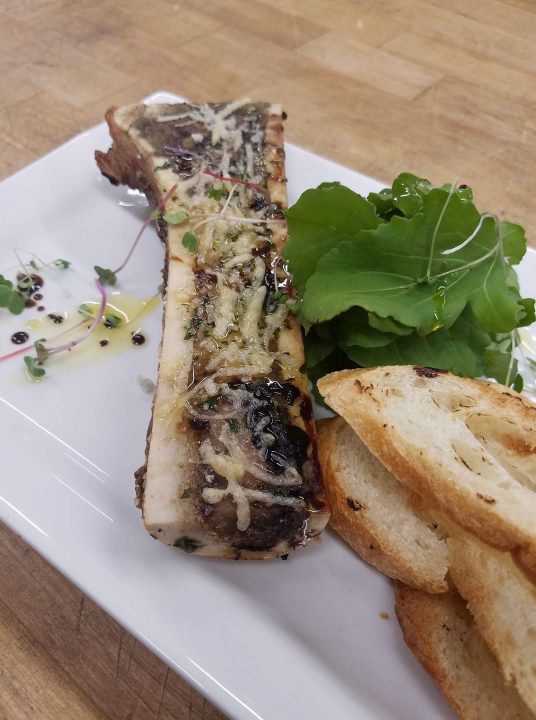 Roasted Carrell Farms water buffalo marrow bone served with greens and bread