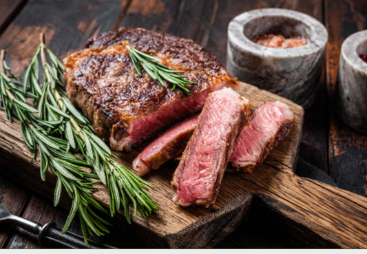 Sliced medium-rare Carrell Farms water buffalo ribeye steak with rosemary