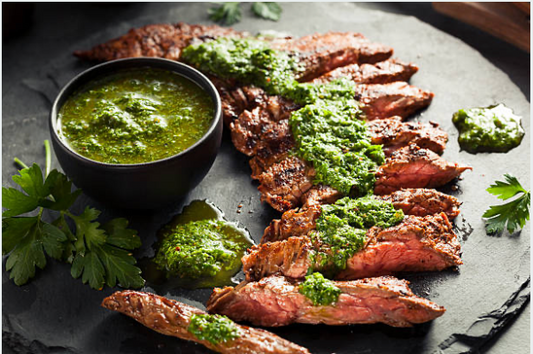 Sliced cooked Carrell Farms water buffalo skirt steak with green herb sauce